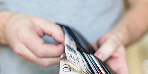person taking bank notes out of a wallet 